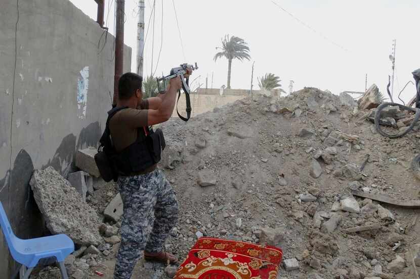 
A federal policeman fires his weapon against Islamic State group militants in the front...