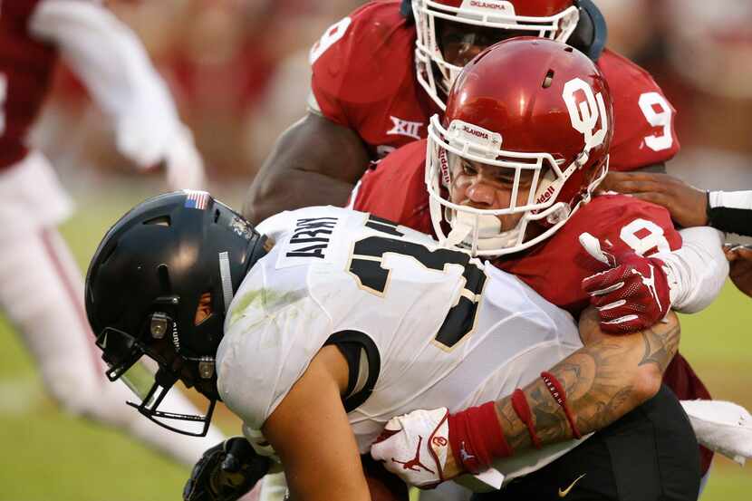 Oklahoma linebacker Curtis Bolton (18) tackles Army running back Darnell Woolfolk (33) in...