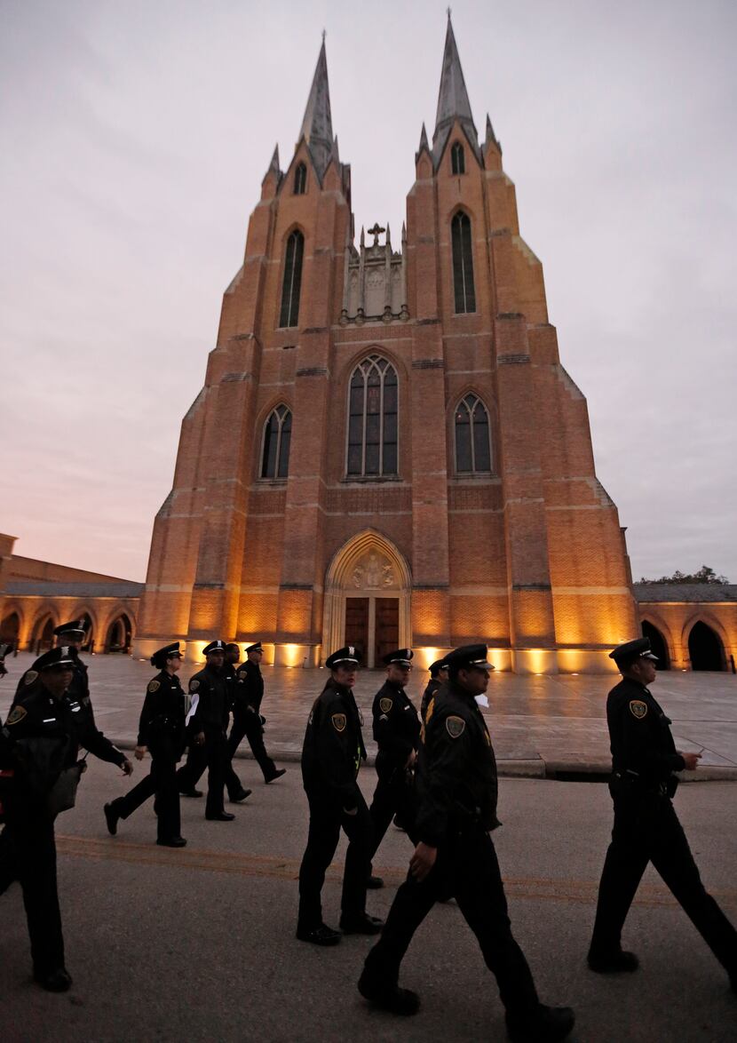 Houston Police officers make their way to their positions before the funeral service for...
