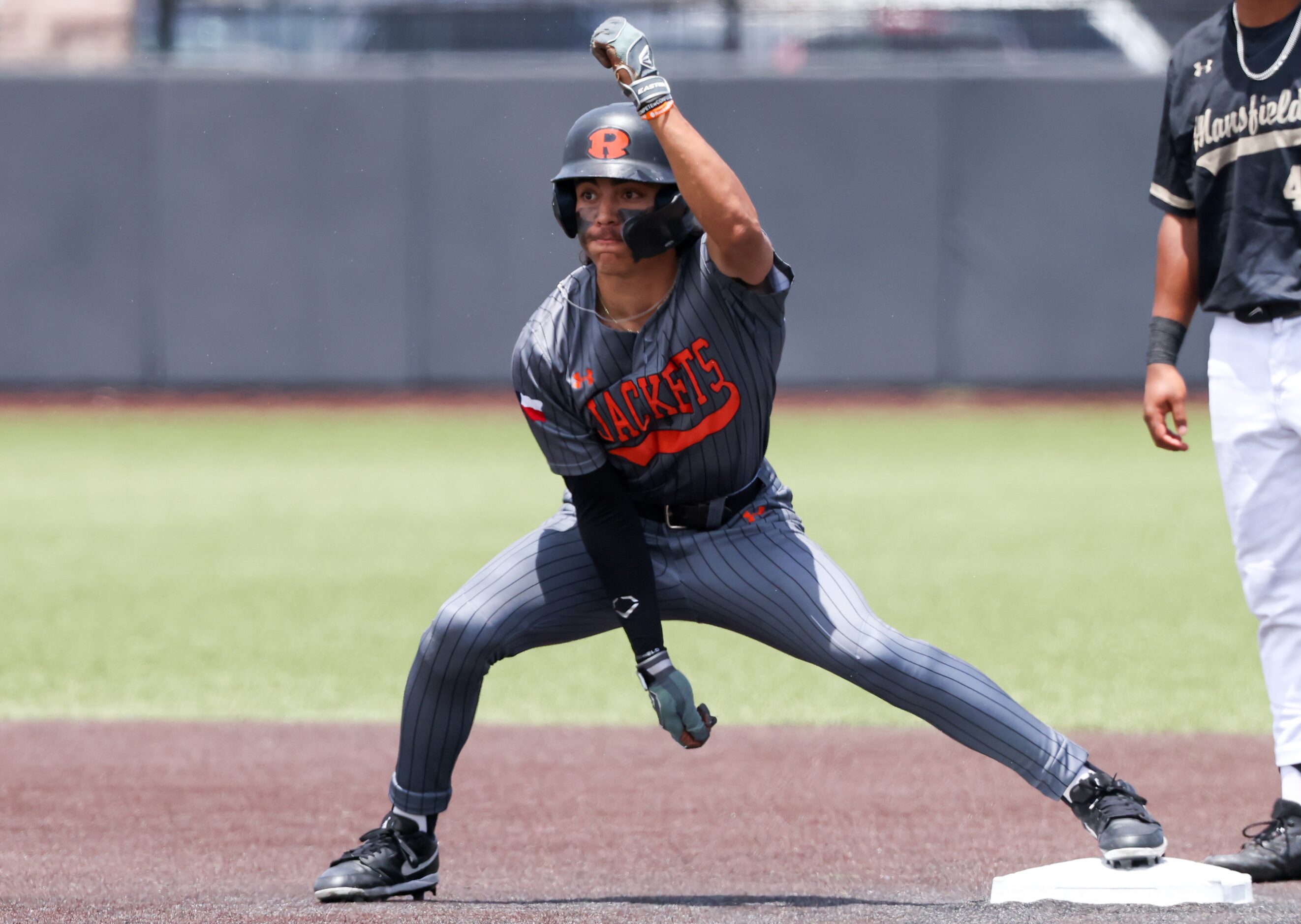 Rockwall senior outfielder Dylan Garcia (left) celebrates running two bases during an area...