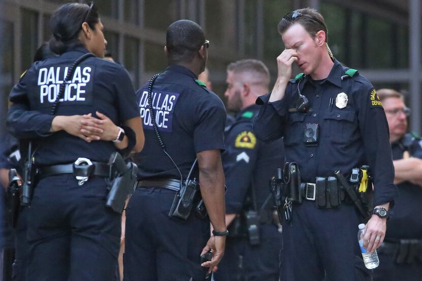 Dallas Police officers are pictured waiting outside at the entrance to the emergency room at...
