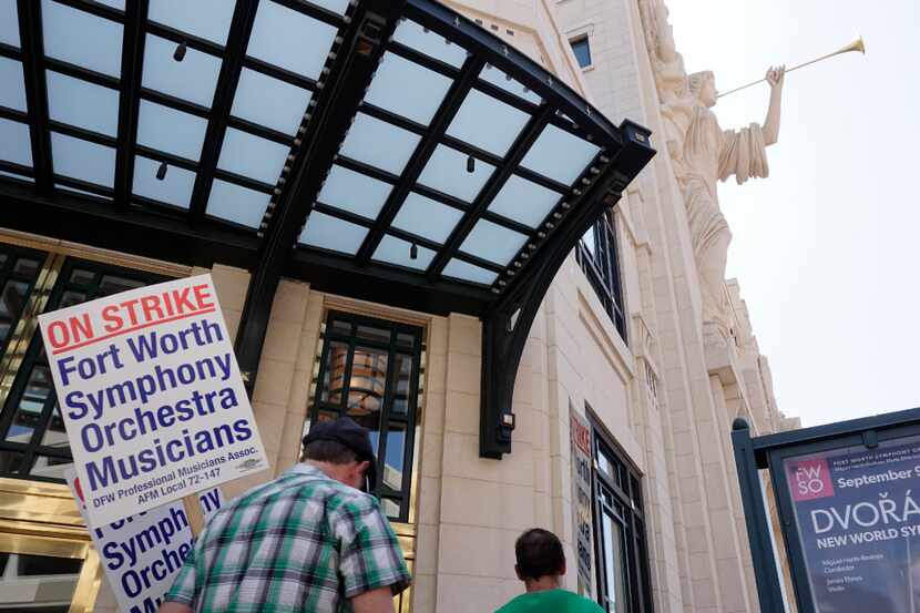Striking Fort Worth Symphony musicians picket under the Bass Hall angels after contracts...