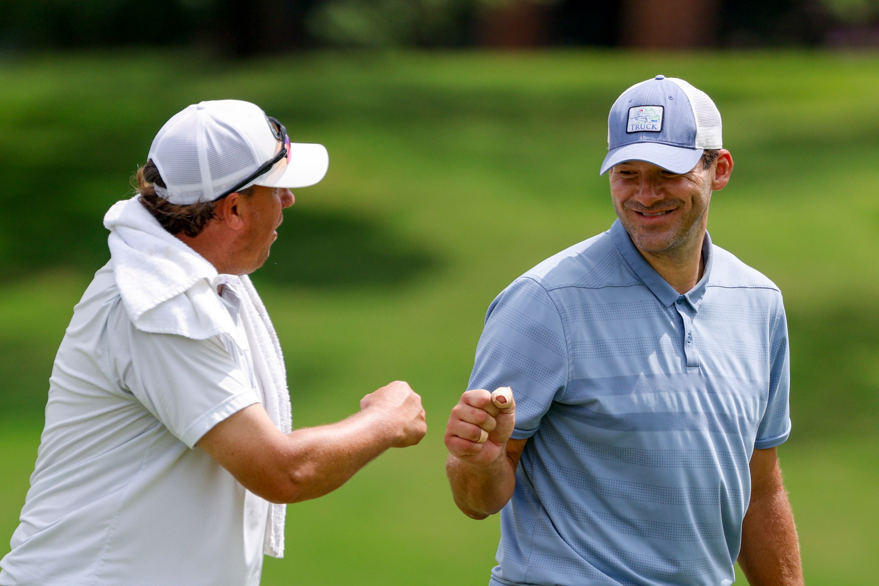 Former Dallas Cowboys quarterback Tony Romo (right) fist bumps caddie Chris Brown after...