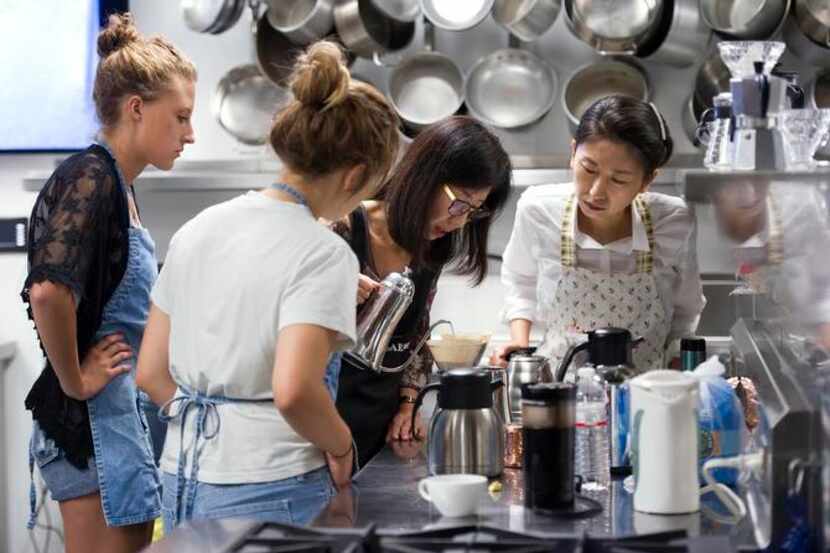 Missy Atkins (left), Jadin Callies and Soo Kyoung Ahn (right), watch a coffee presentation...