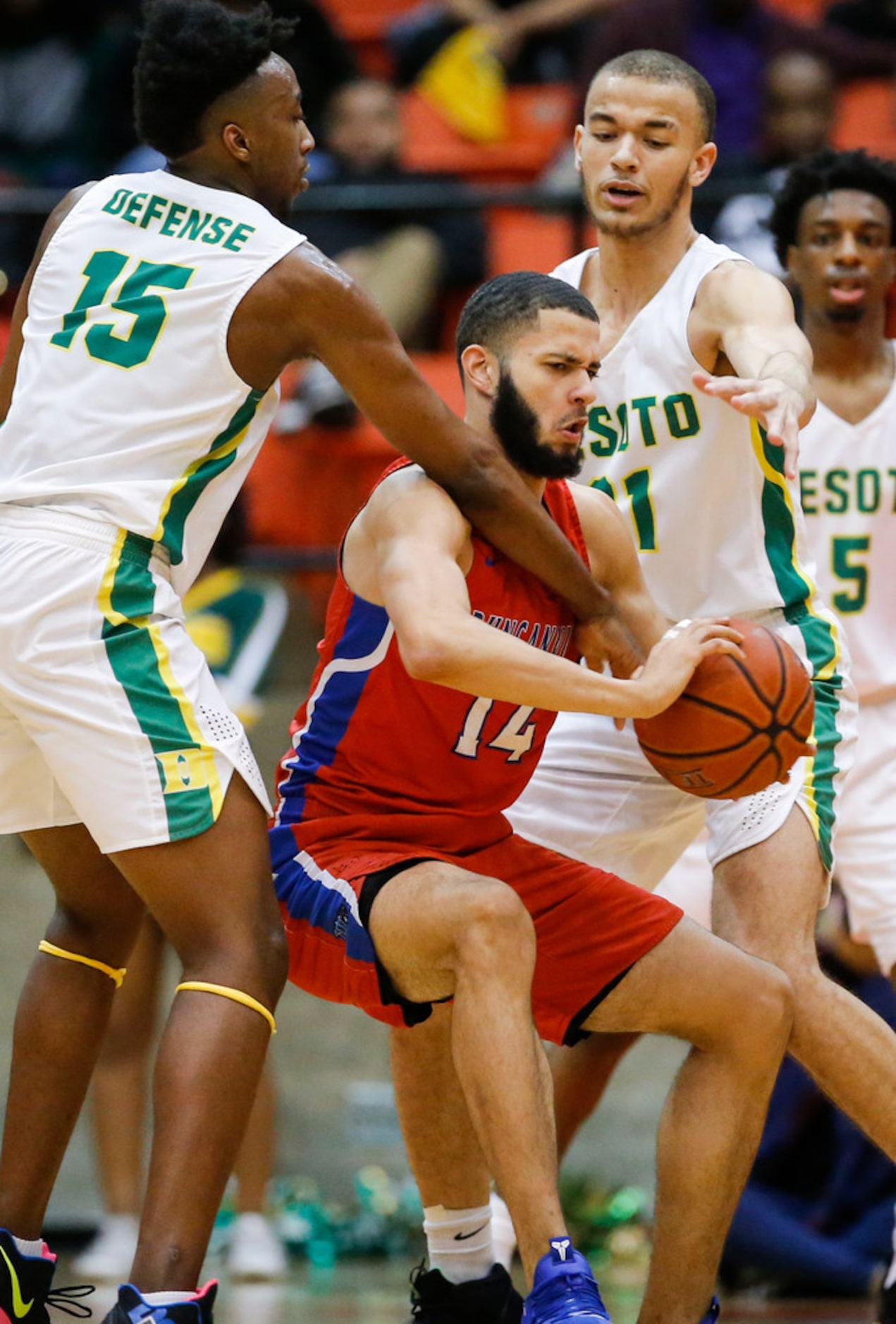 Duncanville junior forward Robert Banks (14) passes as DeSoto senior guard Claven Wilson...