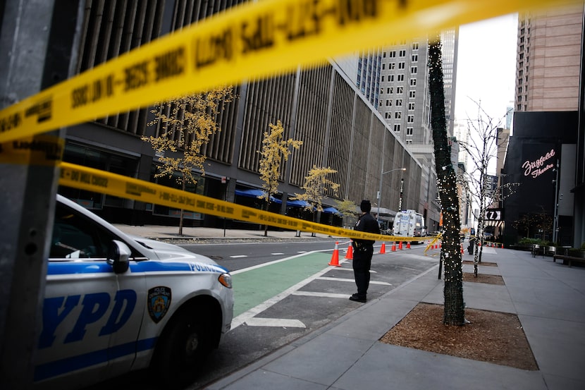 A New York police officer stands on 54th Street outside the Hilton Hotel in midtown...