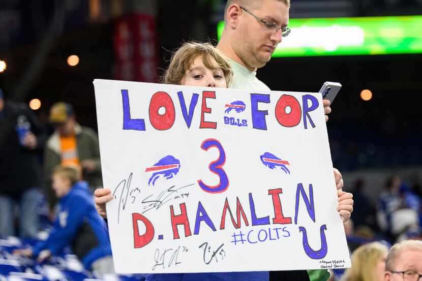A young fan in the stands holds up a sign supporting Damar Hamlin during an NFL football...
