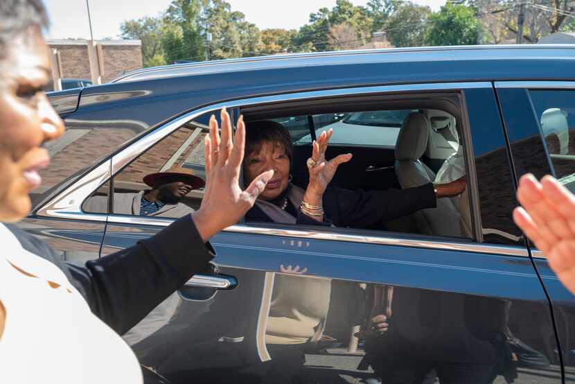 U.S. Rep. Eddie Bernice Johnson, sitting in car, waves goodbye to supporters after she...