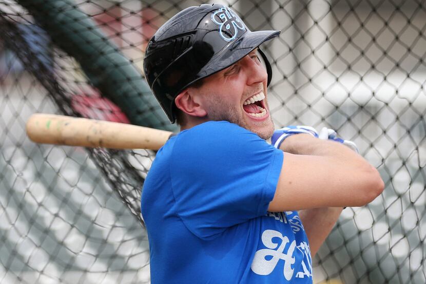 Dallas Mavericks forward Dirk Nowitzki reacts after hitting a ball during batting practice...