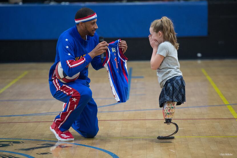 Harlem Globetrotter Julian "Zeus" McClurkin presents Lilly Biagini with her own...