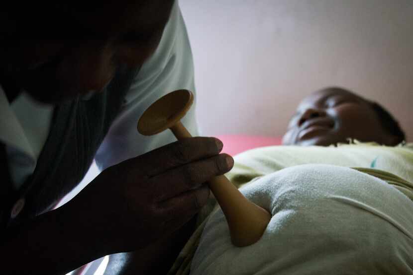 A midwife checks the mother's progress immediately after she is admitted to the health...