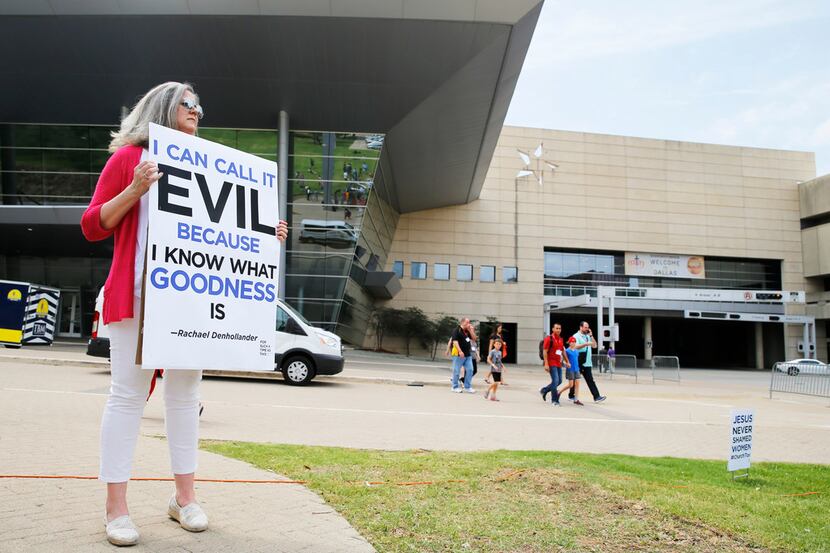 Carol Shelton of Fort Worth holds up a sign as people begin to gather for the "For Such A...