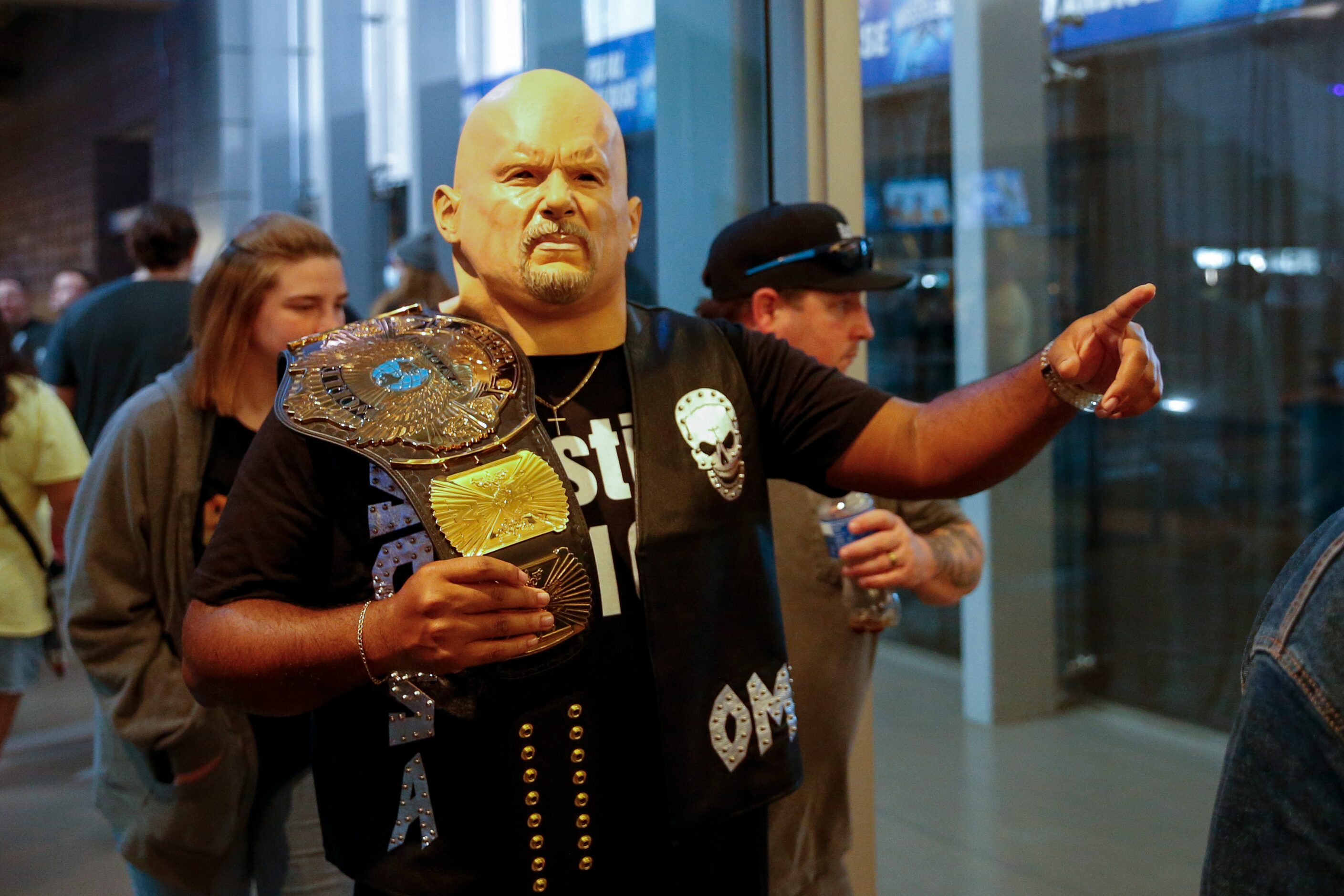 Ari Frazier, 35, poses while wearing a “Stone Cold” Steve Austin mask and vest before...