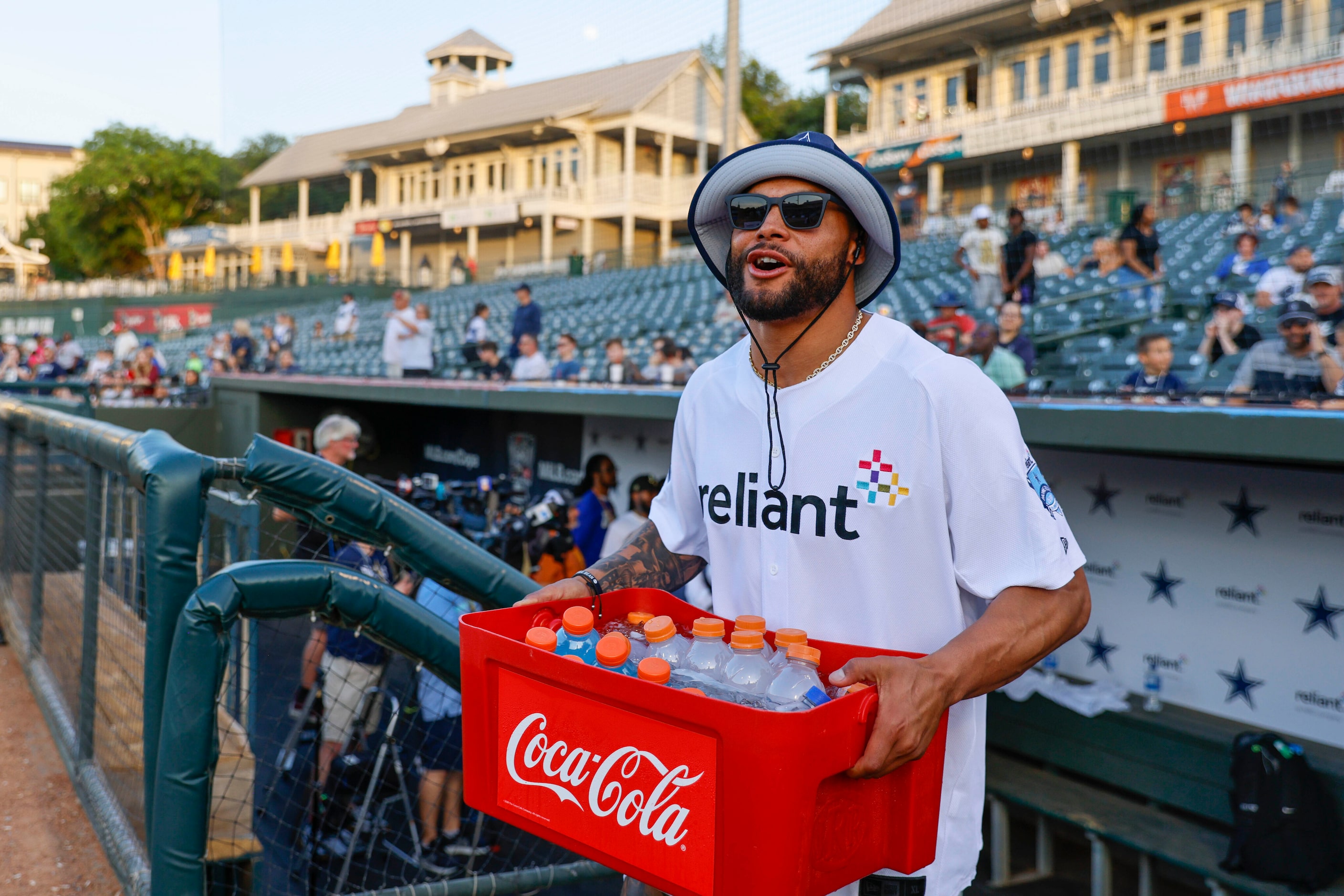 Dallas Cowboys QB Dak Prescott walks out of the dugout carrying a case full of drinks during...