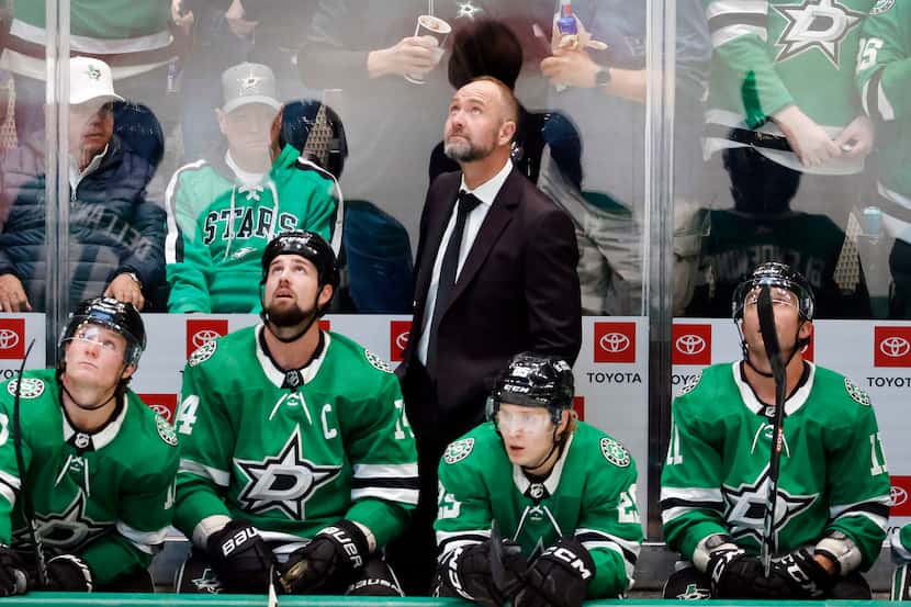 Dallas Stars head coach Peter DeBoer ands players look to the video board for a replay...