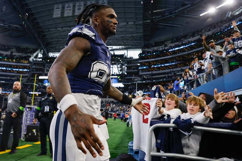 Dallas Cowboys wide receiver CeeDee Lamb (88) high-fives fans after an NFL football game...