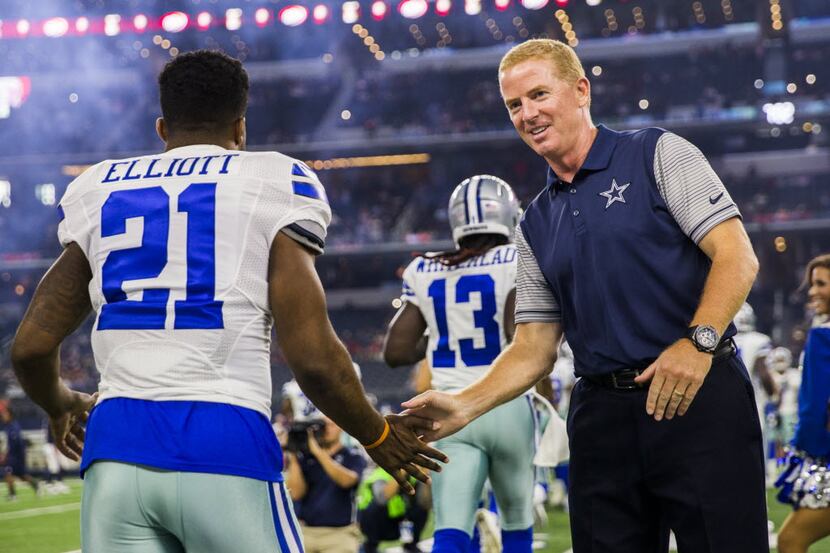 Dallas Cowboys head coach Jason Garrett slaps hands with Dallas Cowboys running back Ezekiel...