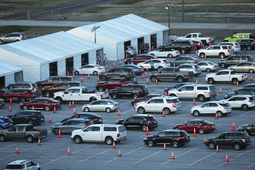 Vehicles line up Tuesday at the new drive-through COVID-19 vaccination clinic at Texas Motor...