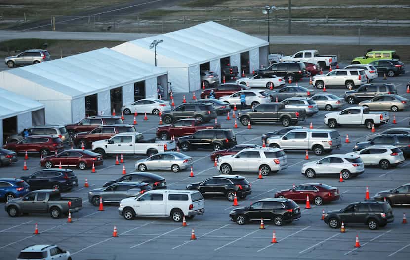 Vehicles line up Tuesday at the new drive-through COVID-19 vaccination clinic at Texas Motor...