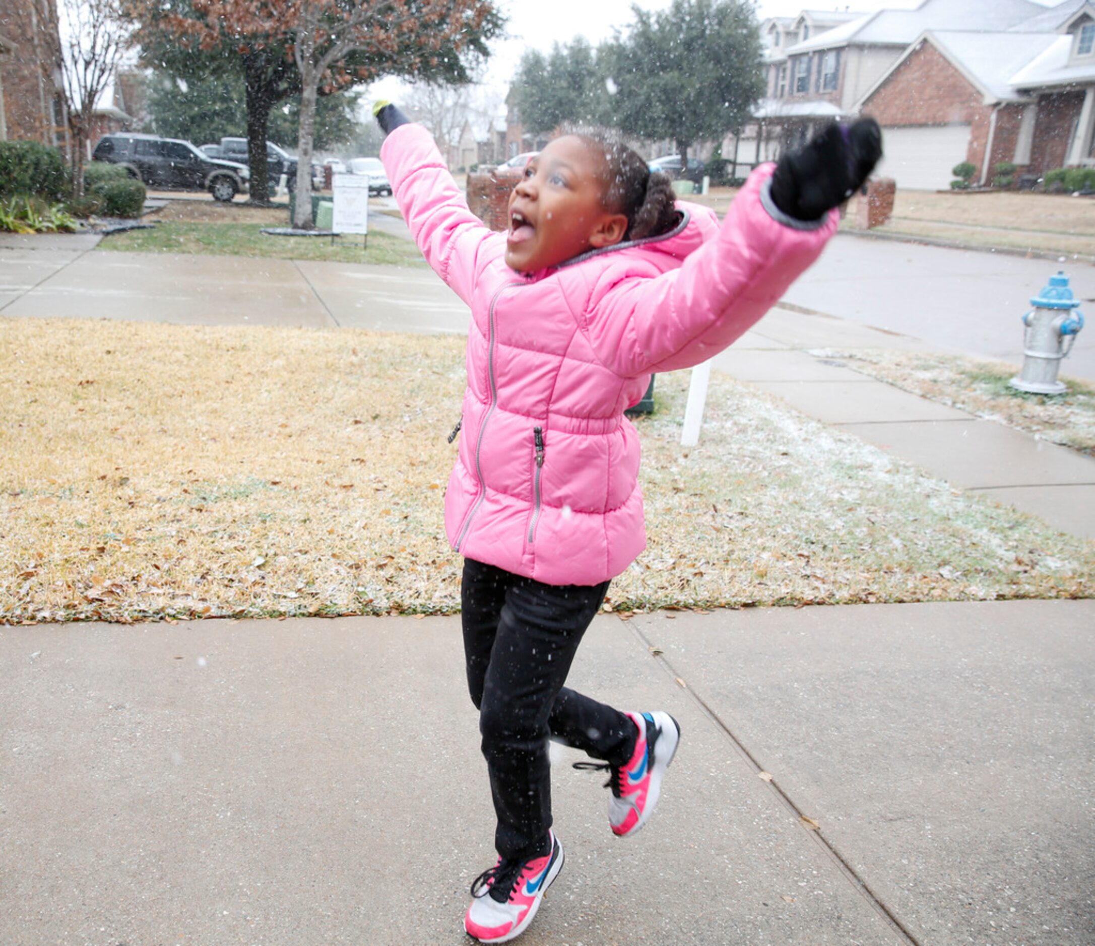 6-year-old Dasiya Small jumps with excitement as it snows in McKinney, Texas Saturday...