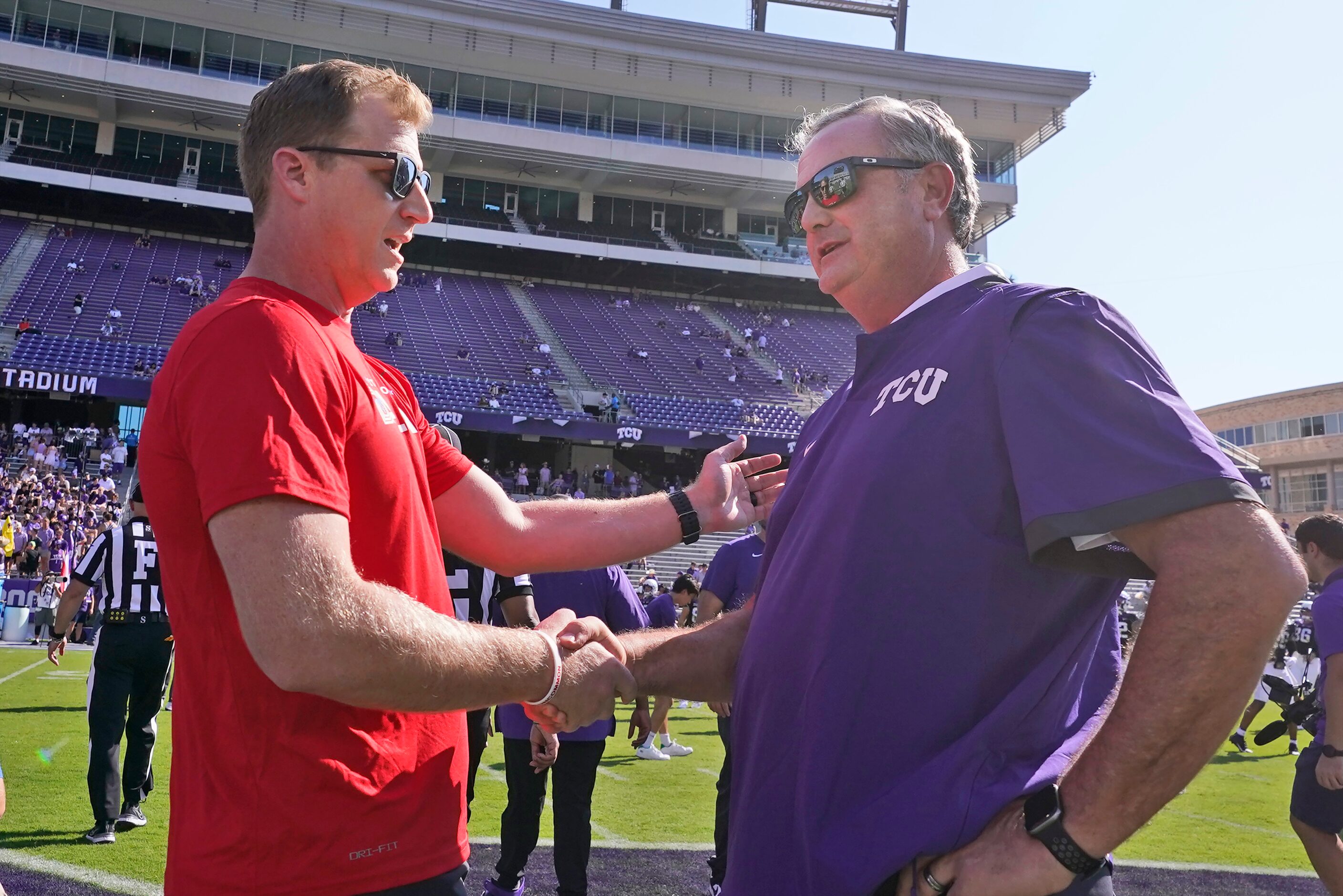 SMU head coach Rhett Lashlee, left, and TCU head coach Sonny Dykes shake hands during...