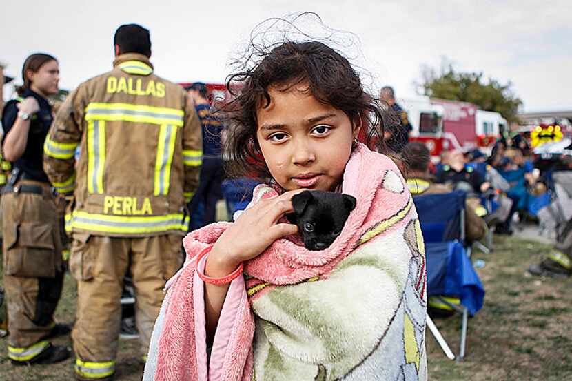 Jennifer Ayala, 9, holds her month-old puppy, Daisy, outside her family's home at Casa De...