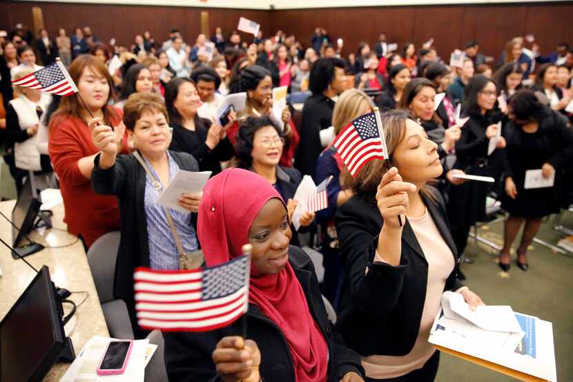 Fatimah Oritola of Nigeria (foreground) of Nigeria and others wave U.S. flags after reciting...