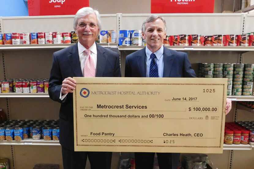 Charles Heath (left), CEO of Metrocrest Hospital Authority, delivered a $100,000 check to...