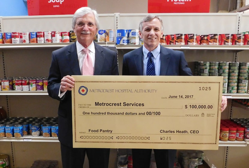 Charles Heath (left), CEO of Metrocrest Hospital Authority, delivered a $100,000 check to...