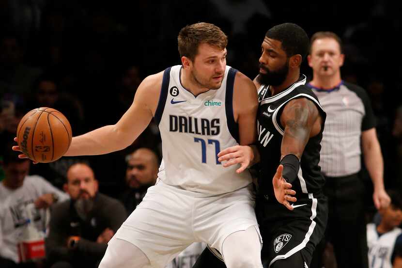 Luka Doncic #77 of the Dallas Mavericks in action against Kyrie Irving #11 of the Brooklyn...