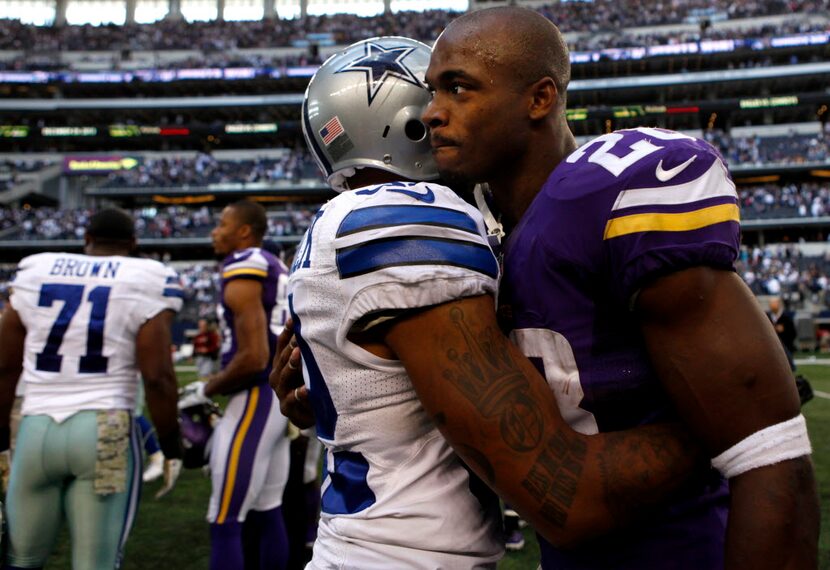 Cowboys Orlando Scandrick, left, hugs Vikings running back Adrian Peterson during the...