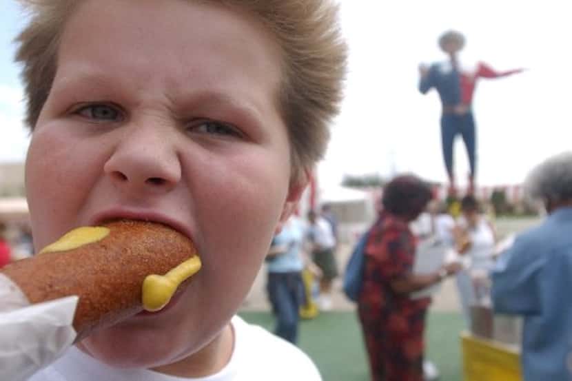 Beau Bunger, 9, takes his first bite of a Fletcher's Corny Dog on the opening day of the...
