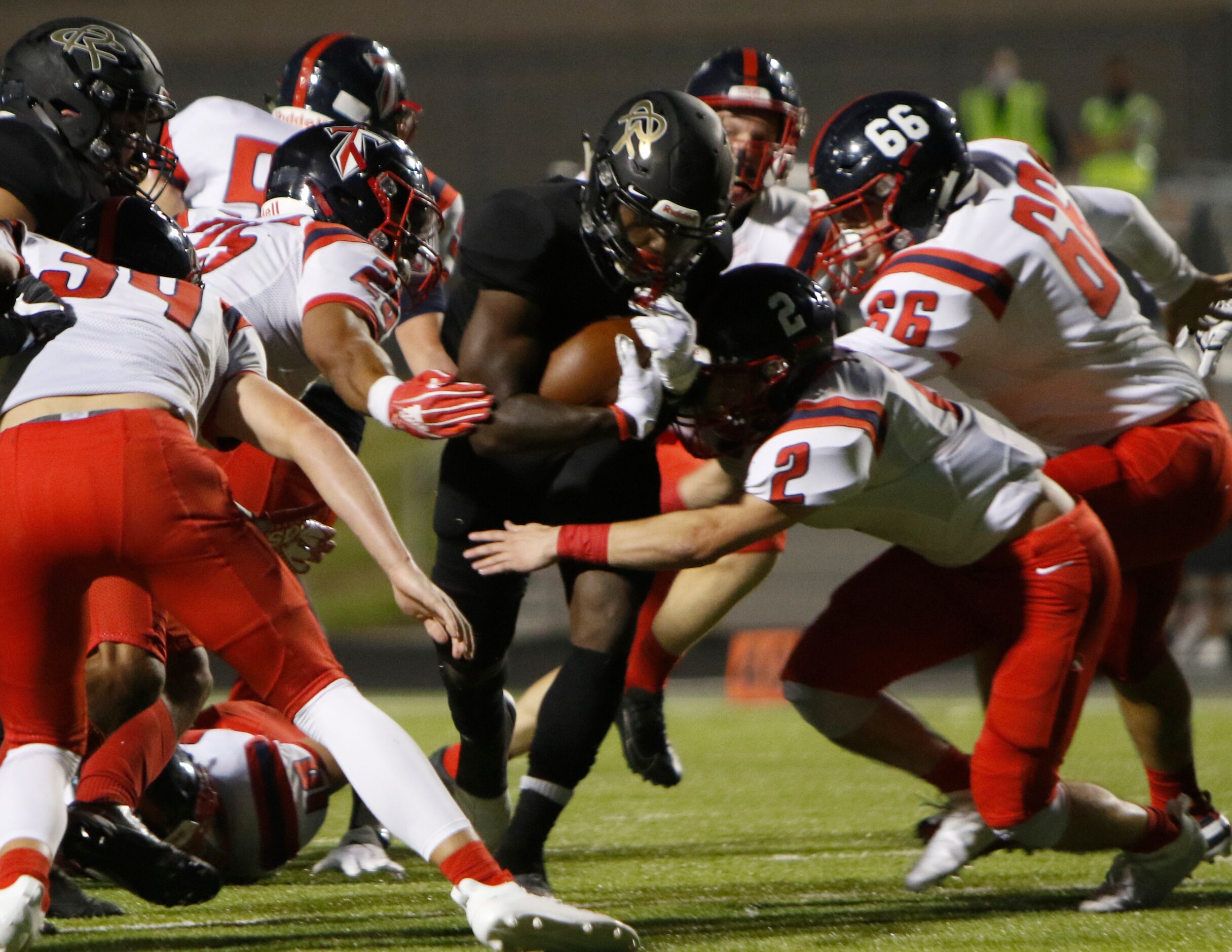 Royse City running back Champ Petty-Dozier (4) draws a crowd of Frisco Centennial defenders...