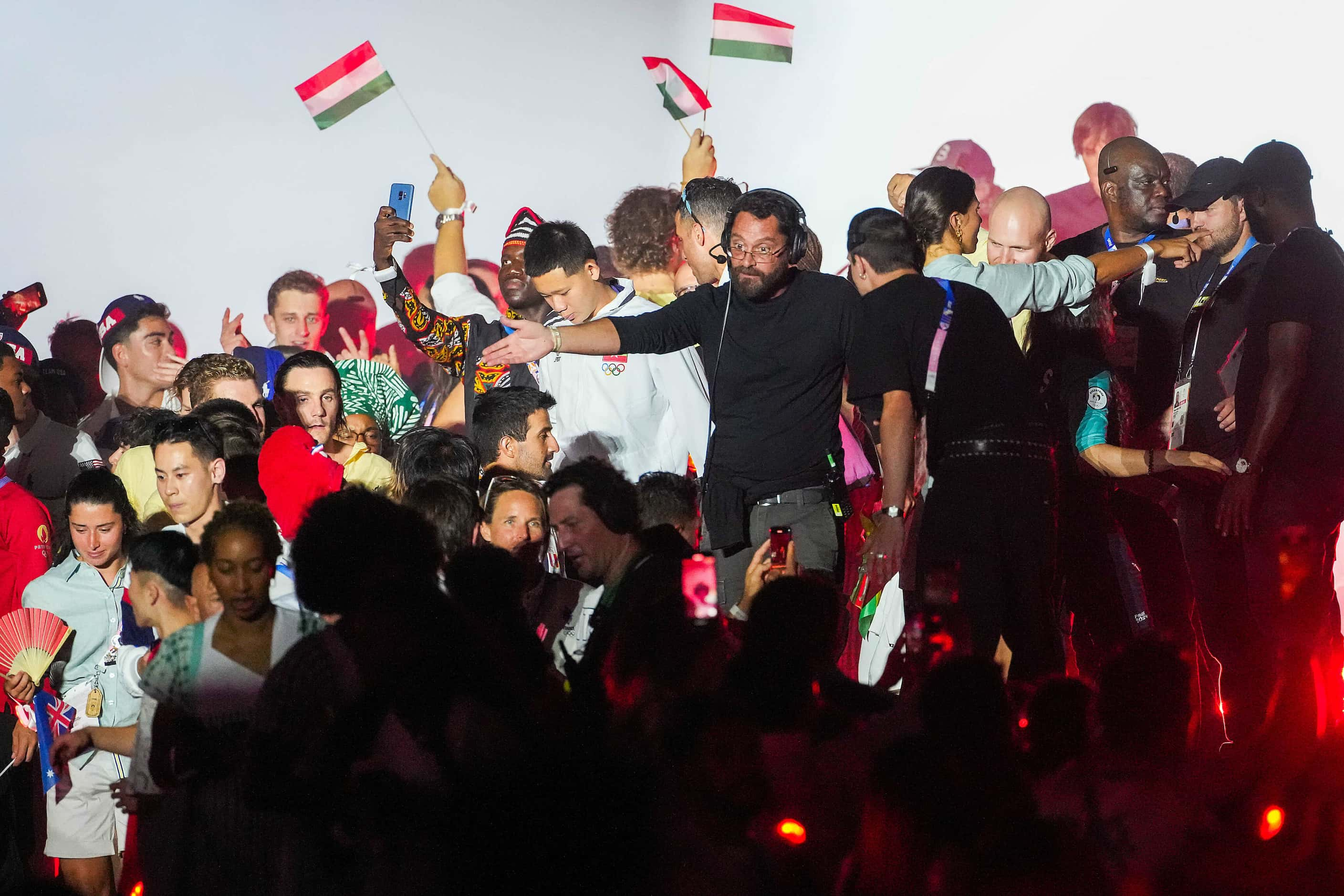 Organizers try to remove athletes who mobbed the stage while French band Phoenix attempted...