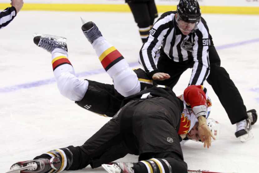 (left to right) Calgary's Steve Begin fights with Dallas' Ryan Garbutt in the first period...