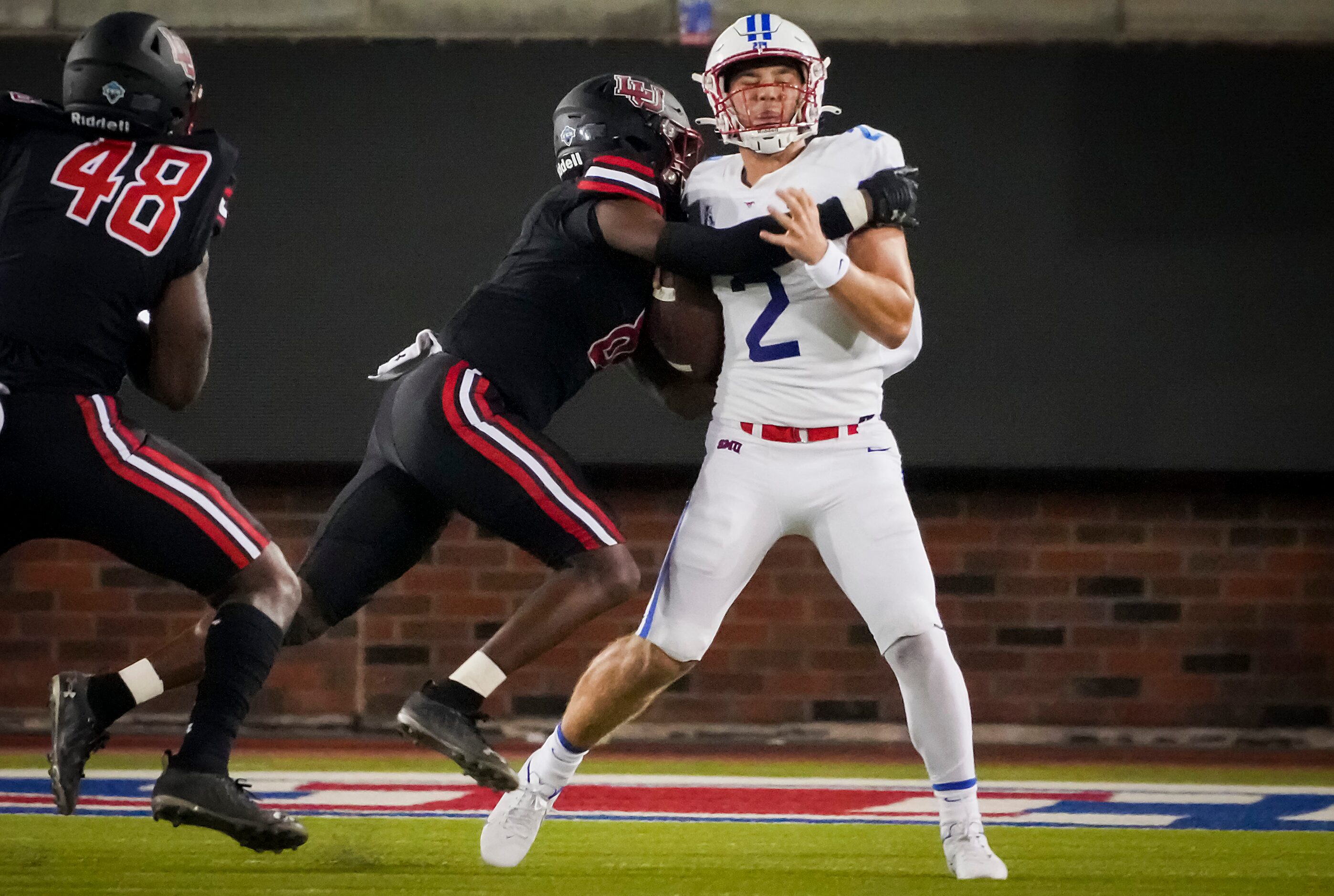 SMU quarterback Preston Stone (2) is sacked by Lamar Cardinals linebacker Caleb Arnold (8)...