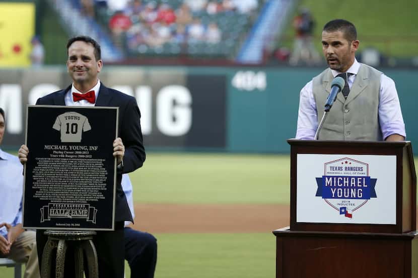 Michael Young (right) speaks after being inducted as a new member of the Rangers Baseball...
