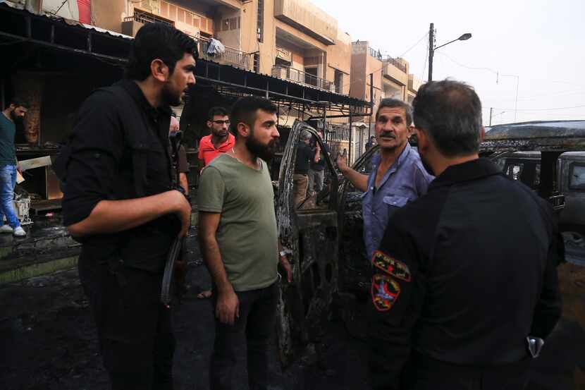 People gather after a car bomb exploded in the town of Qamishli, Syria, Friday, Oct. 11,...