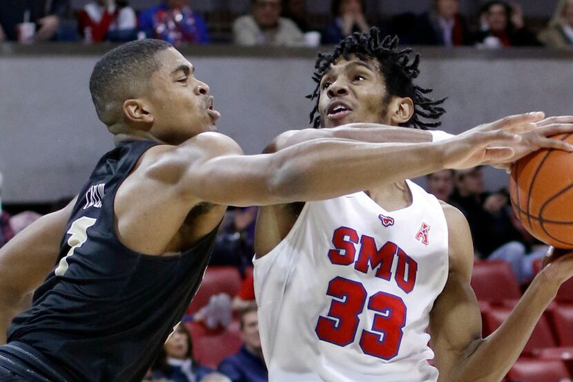 SMU guard Jimmy Whitt Jr. (33) drives strong to the basket against the aggressive defense of...