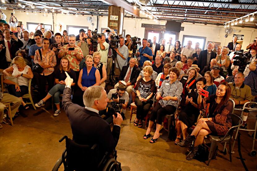  Texas Gov. Greg Abbott (center) speaks to a crowd at Pecan Lodge Thursday, September 17,...