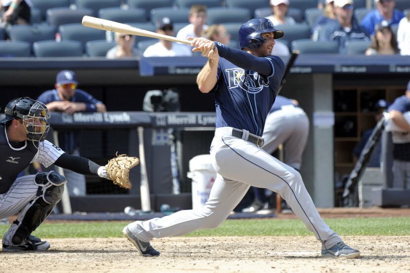 Tampa Bay Rays' Brad Miller hits a home run as New York Yankees catcher Austin Romine, left,...