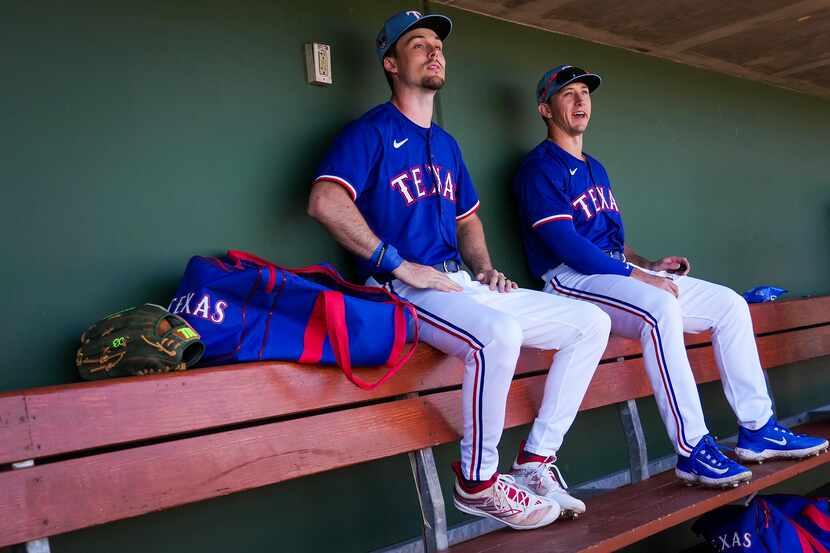 Texas Rangers outfielders Evan Carter and Wyatt Langford look out from the dugout before a...