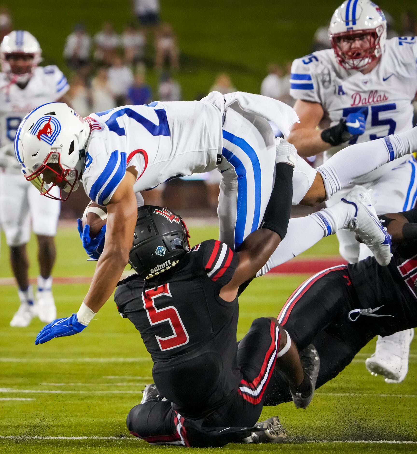 SMU running back TJ McDaniel (25) dives for yardage over Lamar defensive back Damian...