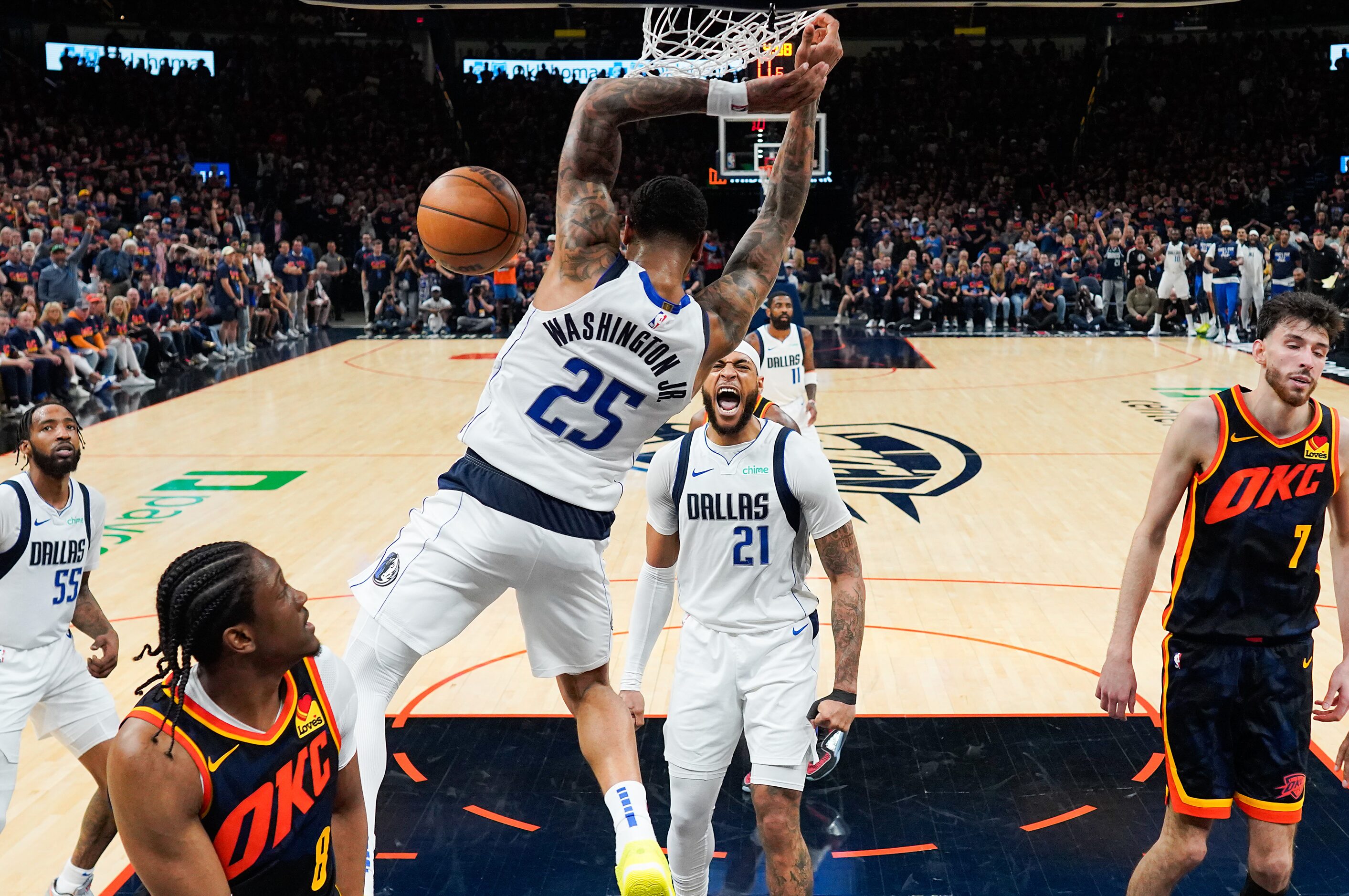 Dallas Mavericks center Daniel Gafford (21) celebrates as forward P.J. Washington (25) dunks...