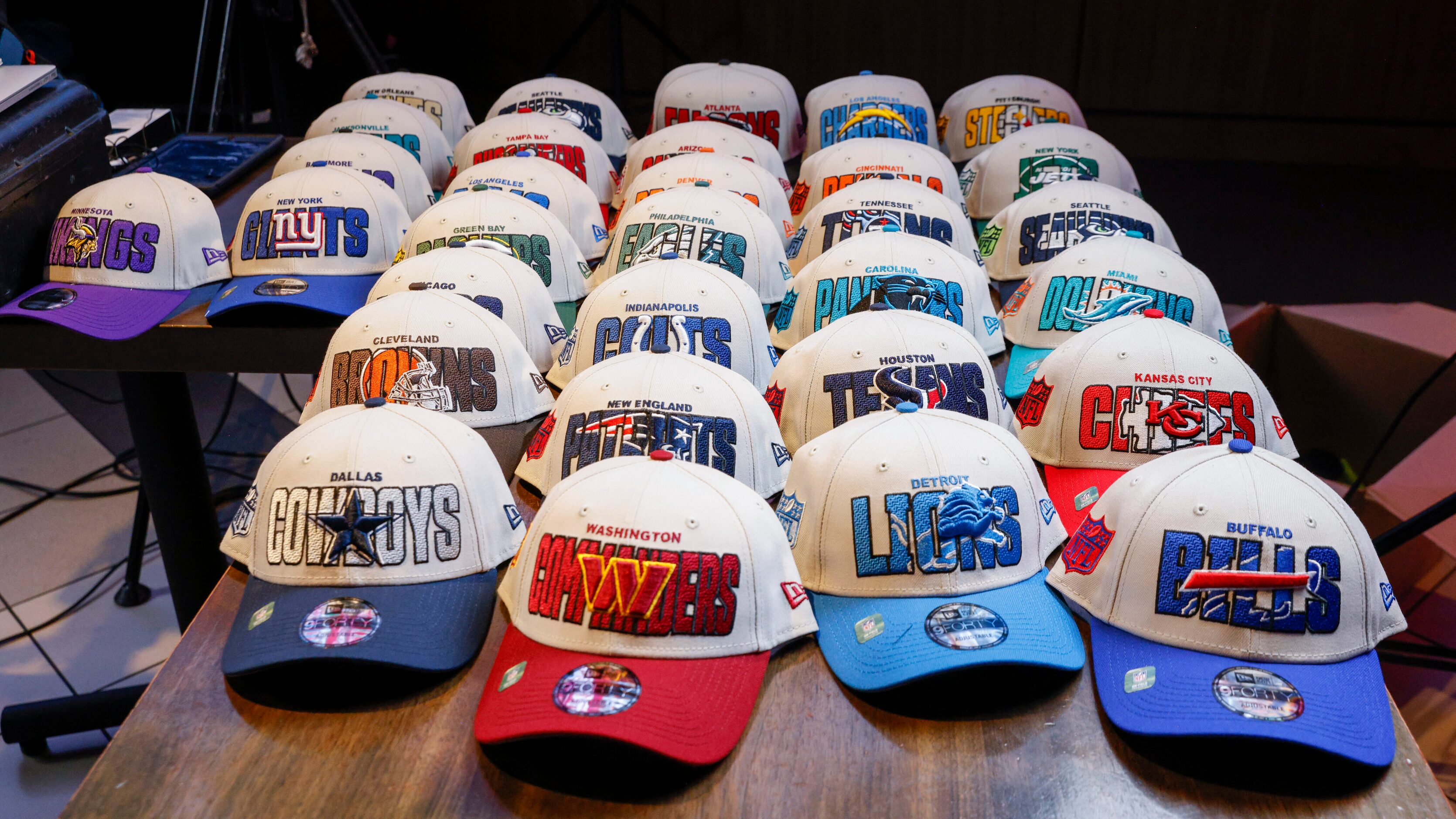 Hats for every NFL team sit on a table during a 2023 NFL Draft party for TCU wide receiver...