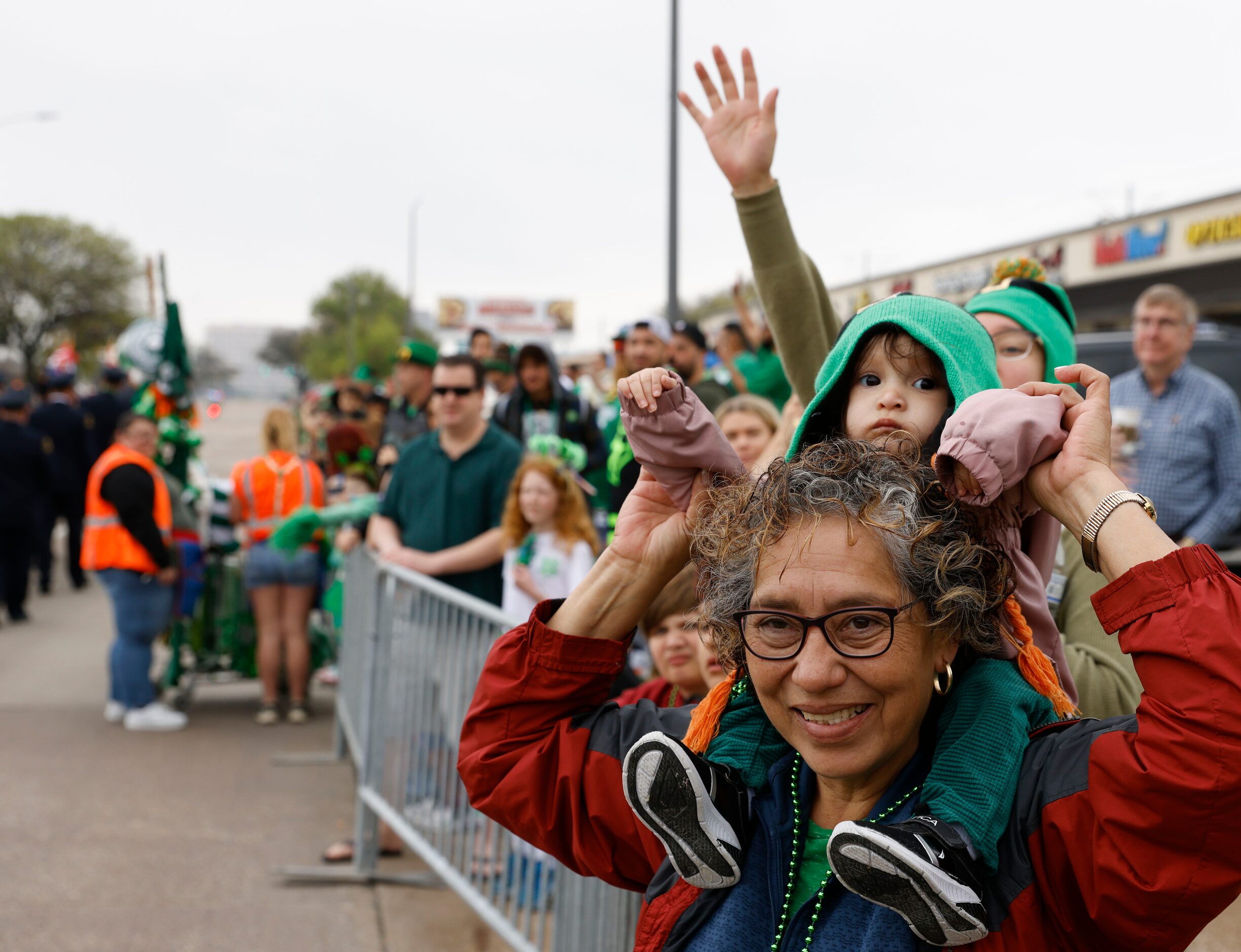 Estelia Gonzalez carrying her granddaughter Ohanna, 1,  cheers during a Saint Patrick's Day...