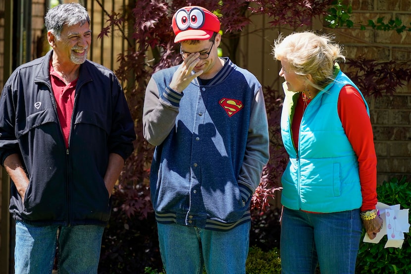 Alex Patterson (center) reacts with his mother and stepfather, Connie and Phil Abookire,...