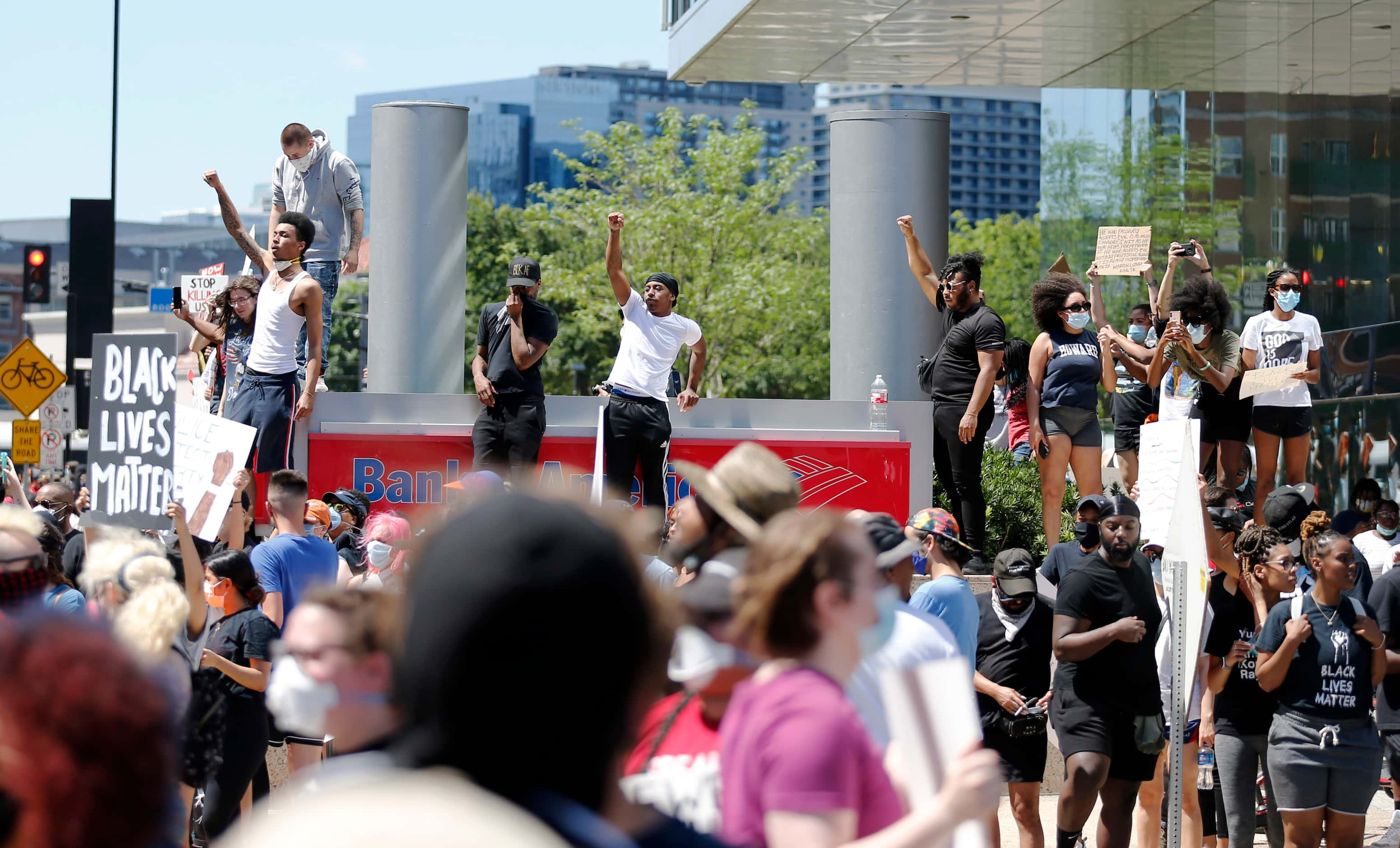 Protesters rally during a demonstration against police brutality next to the Bank of America...