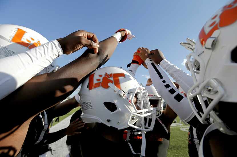 Lancaster players hudle up before a high school football game against   Mansfield Lake Ridge...