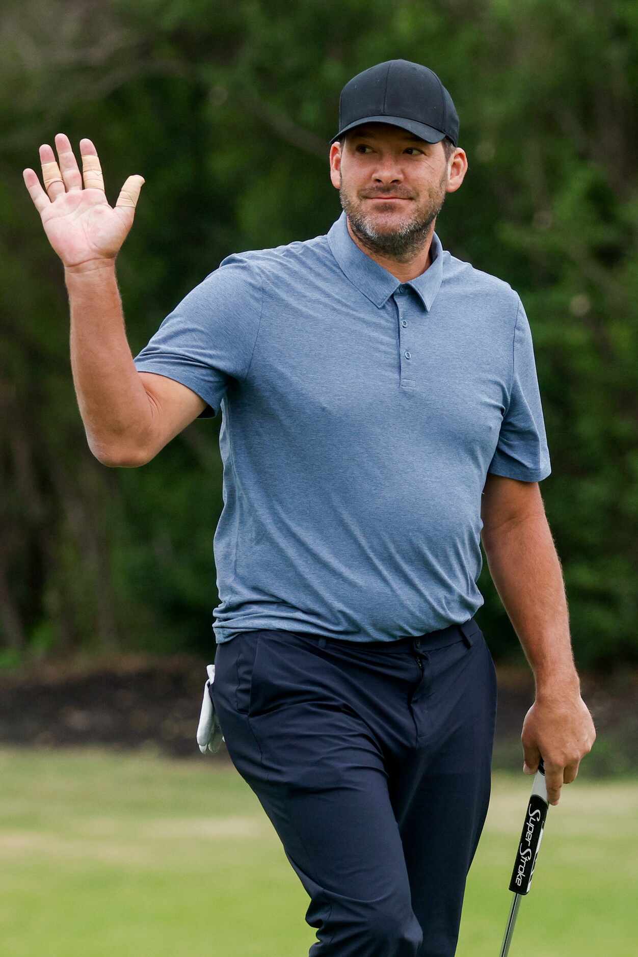 Former Dallas Cowboys quarterback Tony Romo waves to the crowd after his putt on the 17th...